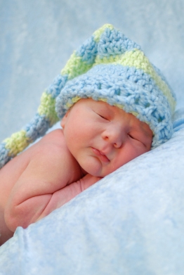 newborn wearing long crocheted hat