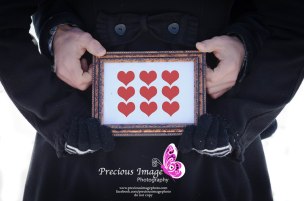 photo of frame with hearts being held by couples hands
